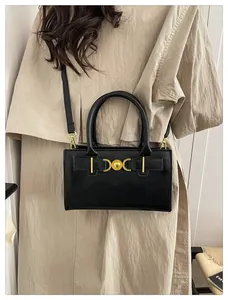 Dettaglio della borsa in pelle nera con fibbia dorata a cuore e mezzaluna e tracolla