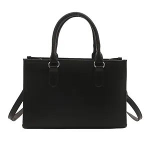 Minimalist black rectangular tote bag with textured surface and silver metal hardware