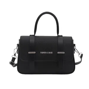 Elegante bolso caja negro con grano de lichi, asa superior y detalles metálicos plateados