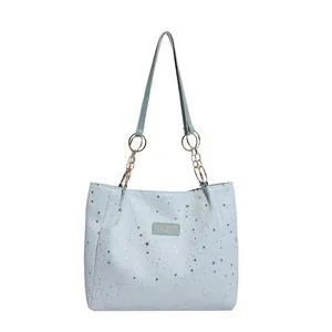 Light blue tote bag with silver stars and gold chain strap on white background