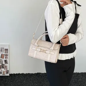 Elegant cream crocodile pattern handbag with gold heart buckle shown on a model