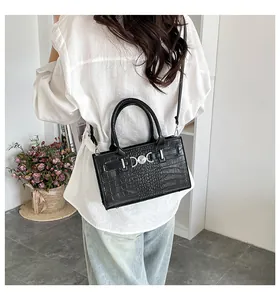Detailed view of black crocodile pattern leather tote with silver hardware and shoulder strap