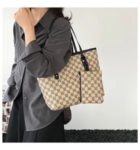 Detail of retro M-print tote bag set with matching small pouch and black shoulder strap