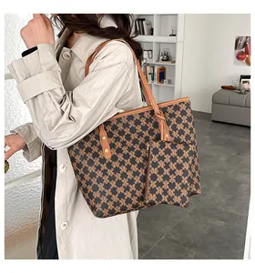 Close-up of retro tote bag with monogram pattern and matching small pouch accessory