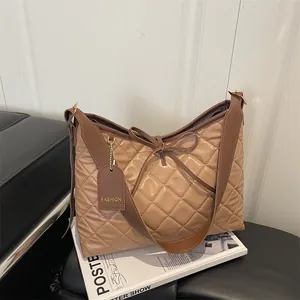 Quilted oversized tote bag with bow detail and brown faux leather trim for daily commute