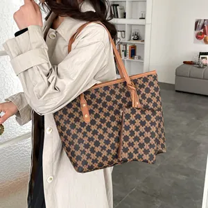 Large dark brown tote bag set with monogram pattern shown on a model in a trench coat