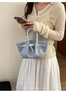 Detail view of light blue woven leather handbag with stylish belt buckle accents