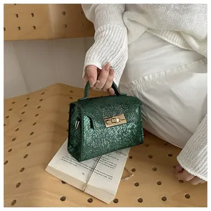 Detailed view of the dark green snake texture flap bag with a golden turn-lock clasp