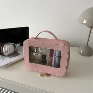 Pink portable travel makeup bag with clear PVC window and golden dual zippers