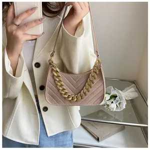 Detailed view of beige felt baguette bag featuring V-shaped quilting and gold chunky chain