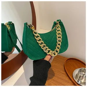 Detail of green felt baguette bag with V-shaped quilting and chunky gold chain strap