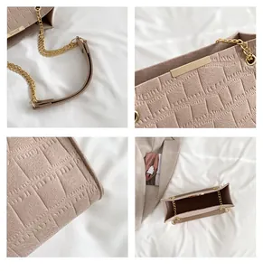 Details einer Handtasche aus Kunstleder mit Krokoprägung, goldener Kette und Magnetverschluss