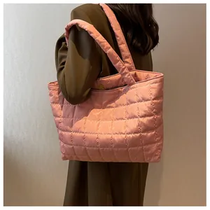 Detail of pink quilted tote bag with large diamond stitching and magnetic closure