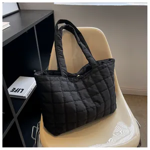 Detail of black quilted tote bag with soft padded texture on a modern chair