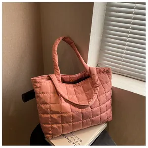 Close-up of soft pink quilted puffer tote bag with waterproof nylon texture and stitching