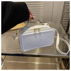 Detail of white PU leather handbag with gold zippers and FASHION & BAG embossed text