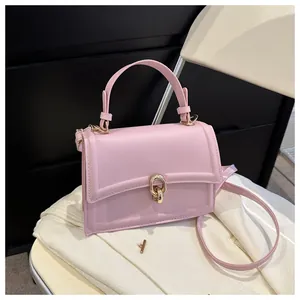 Detail of pink faux leather handbag with elegant gold ring lock and top handle