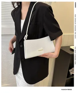 Détail du sac baguette blanc avec logo FASHION et bandoulière à nœuds fins