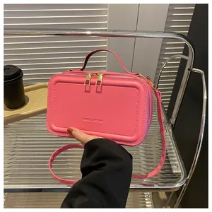 Detail of hot pink crossbody bag with FASHION&BAG logo and elegant top handle