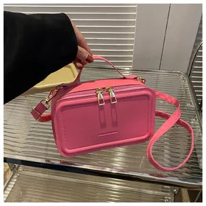 Detailed view of pink rectangular crossbody bag with FASHION&BAG text and gold dual zippers