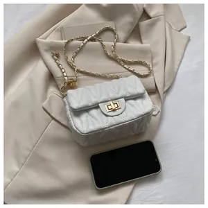 Detail of white quilted crossbody bag with gold chain strap and decorative metal ball