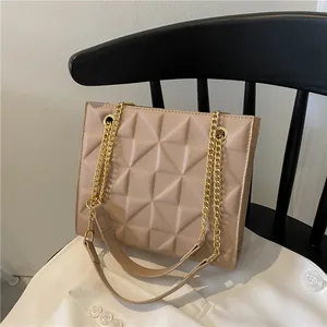 Beige crossbody bag with geometric triangle quilting and golden chain strap