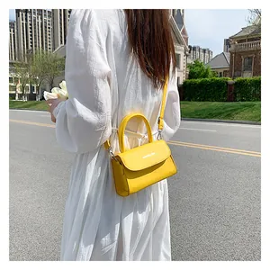 Detailed view of bright yellow mini crossbody bag with Fashion & Bag printed on flap
