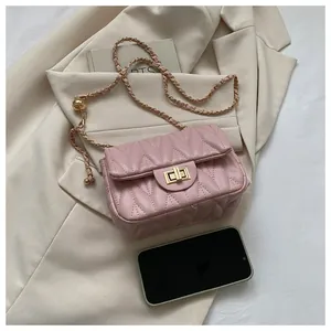 Detail of pink quilted leather crossbody bag featuring gold chain strap and spherical adjuster