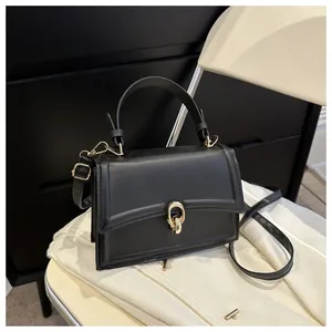 Close-up of black crossbody bag with premium matte finish and golden ring metal buckle