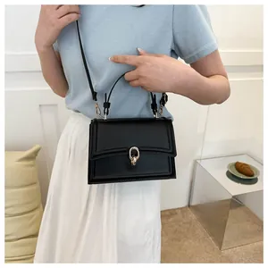 Close-up of black PU leather crossbody bag with golden metal ring clasp and handle