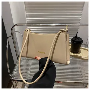 Détail du sac baguette en similicuir abricot avec logo Fashion doré sur support en métal