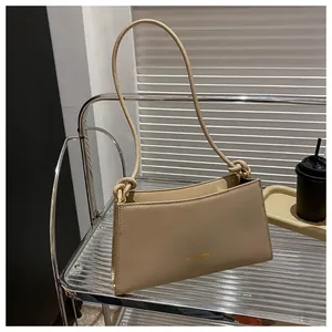 Détail du sac beige avec bandoulière nouée et inscription FASHION dorée sur le devant