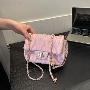 Elegant pink quilted crossbody bag with golden chain strap and chic metal ball ornament