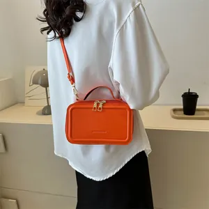 Fashionable orange PU leather crossbody bag with top handle and gold zipper hardware