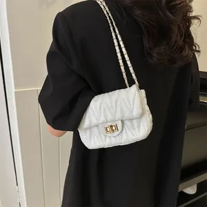 Minimalist white quilted crossbody bag with gold chain strap and metal turn-lock