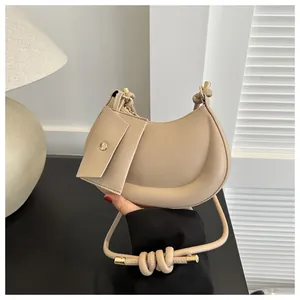 Nahaufnahme der beigen Halbmondtasche mit Mini-Beutel und geknoteten Riemendetails