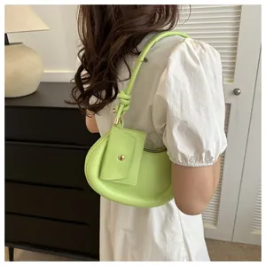 Detail der neongrünen Halbmond-Tasche mit flauschigem Rand und kleinem Anhänger