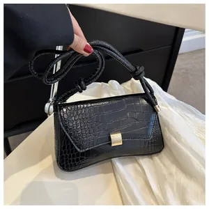 Détail de la texture crocodile noire avec un fermoir doré élégant sur le sac à main