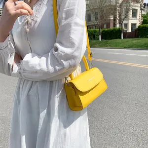 Fashionable bright yellow square handbag with top handle and shoulder strap for women