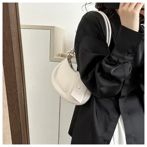 Detailaufnahme einer weißen Croissant-Tasche mit Knotengurt und passendem Kartenetui