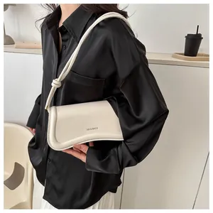 Close-up of the cream rectangular leather underarm bag with XM & BAGS logo detail