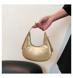 Close-up of champagne gold crescent hobo bag with embossed crocodile texture