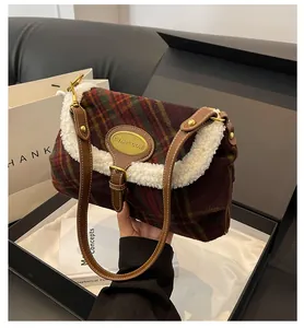 Detail of plaid shoulder bag featuring soft white faux shearling trim and golden hardware