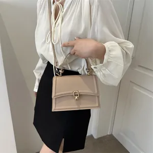 Elegant beige crossbody bag with gold ring buckle and shoulder strap in a minimalist style