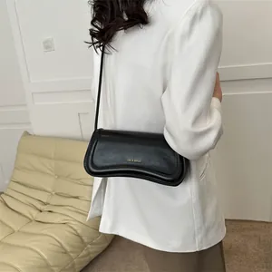 Minimalist black leather underarm shoulder bag for women with gold logo and matte finish