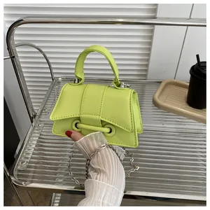 Détail du mini sac bandoulière vert néon avec chaîne argentée sur support métal