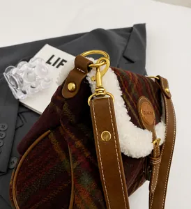 Detail of plaid wool shoulder bag with plush shearling trim and golden metal clasp