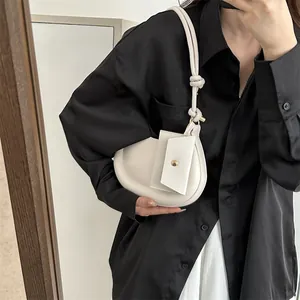 Minimalistische weiße Halbmond-Umhängetasche mit stilvollem Knotendetail am Riemen
