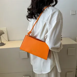 Sac baguette orange vif minimaliste avec inscription tendance et bandoulière à nœuds