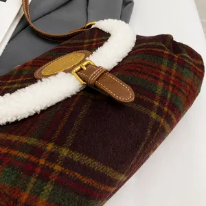 Detailed macro view of red and green plaid fabric with plush faux fur trim and leather strap